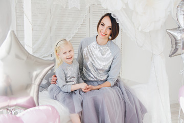 Mother and daughter in beautiful outfits celebrate the holiday