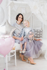 Fototapeta na wymiar Mother and daughter in beautiful outfits celebrate the holiday