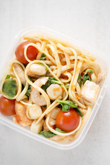 Seafood linguini with shrimps, salmon, scallops, spinach and tomatoes 