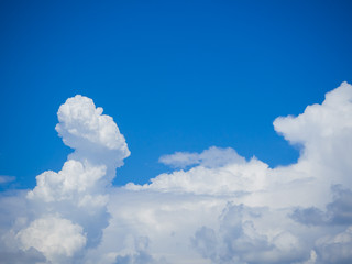 Naklejka na ściany i meble White cumulonimbus clouds of intricate shape on a blue sky.