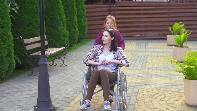 daughter in the Park disabled mother in a wheelchair steady shot slow mo