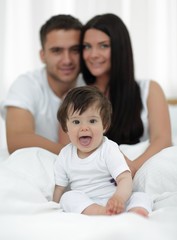 Obraz premium Happy couple and son sitting in bed