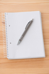 Schreibblock  mit Kugelschreiber liegt auf einem Tisch