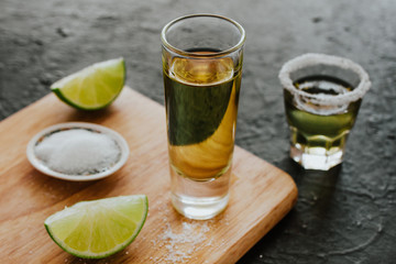 Tequila shot, mexican Alcoholic strong drinks and pieces of lime with salt in mexico