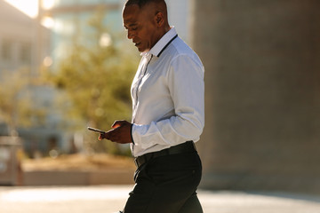Man using mobile phone while walking on street