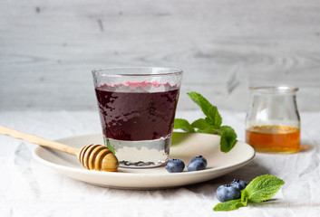Healthy detox drink with blueberries, honey and mint.