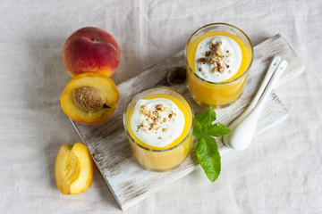 Peach dessert (mousse) with natural yoghurt, walnuts and mint in portion glasses