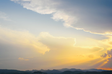 Beautiful sunset with the sun of orange tones behind the mountains and deep blue sky