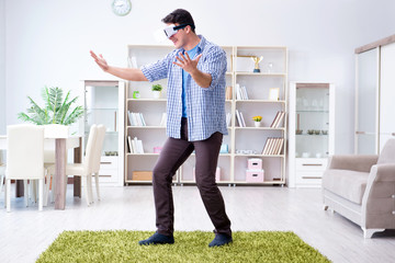 Man with virtual reality glasses playing at home