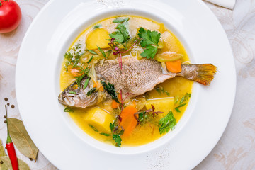 Fish soup on white plate