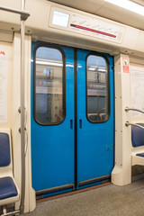 View of bright empty interior of modern subway train car. Contemporary inside space of the underground railway carriage with no one inside, empty seats.