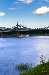 Summer view of the Volga river and cruise pleasure boat and the old Volga bridge, city of Tver, Russia.