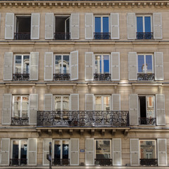 Fototapeta na wymiar Fenêtres et reflets du soleil sur fenêtres de vieux bâtiment parisien