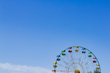 Ferris wheel against a blue sky on a sunny day.