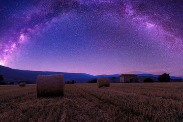 The summer Milky Way over  farmland and straw bales in Provence