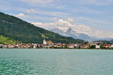Fototapeta na wymiar Zugersee mit Gemeinde Arth. Im Hintergrund der grosse und der kleine Mythen - Berge der Zentralschweiz