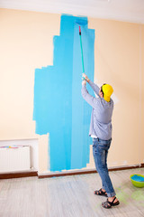 Painter man painting the wall at home