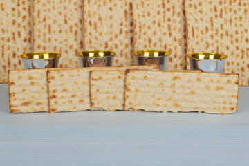 Four cups of Passover wine close up matzah texture in background.