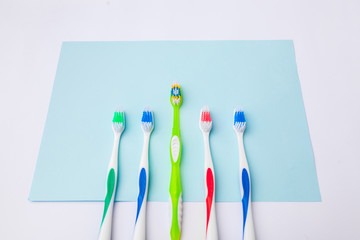 Toothbrushes on light blue background, close up different kinds of Toothbrushes, new not used, isolated for text insertion, one of the best, old and new brushes