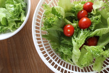 lettuce leaves and tomatoes hand on a wooden background