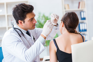 Doctor checking patients ear during medical examination