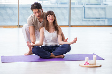 Personal coach helping during yoga session