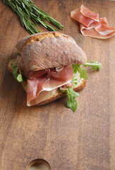 sandwich with prosciutto jamon on a wooden background