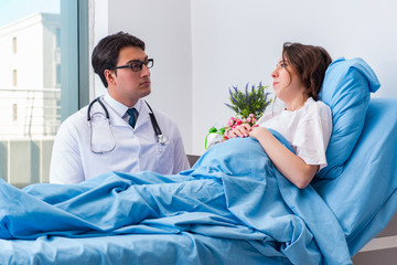 Doctor visiting pregnant in hospital room