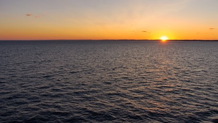 Ocean sunset with sun barely visible on horizon