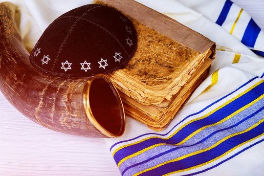 Top view of shofar horn on white prayer talit.Prayer Shawl Torah and a kippah a yamolka and Shofar horn jewish religious symbol