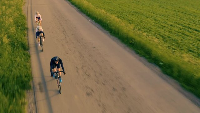 Mid air detail top view of road bikers in the countryside on the sunrise