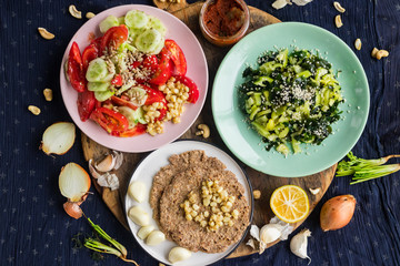 Vegan vegetarian lunch or dinner with vegetables salads, homemade whole wheat breads and tomato sauce paste. Raw healthy food. Paleo trendy diet.