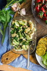 Vegetables salad with cucumbers, sauce, garlic, grated walnuts, parsley and green herbs. Served with tomato sauce. Raw vegan vegetarian food. Paleo diet