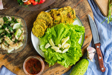 Fresh homemade bread of whole wheat flour with turmeric powder, parsley and garlic on plate with fresh green salad leaves. Vegetarian lunch and vegan dinner. Paleo healthy food diet