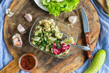 Vegetables salad with cucumbers, sauce, garlic, grated walnuts, parsley and green herbs. Served with tomato sauce. Raw vegan vegetarian food. Paleo diet