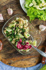 Vegetables salad with cucumbers, sauce, garlic, grated walnuts, parsley and green herbs. Served with tomato sauce. Raw vegan vegetarian food. Paleo diet