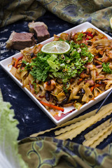 Asian fried noodles with vegetables, prawn and octopus meat cooked in soy sauce. Traditional authentic food in asian cafe or restaurant. Eat with chopsticks