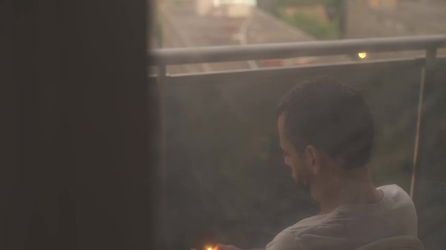 Man smoking on balcony.