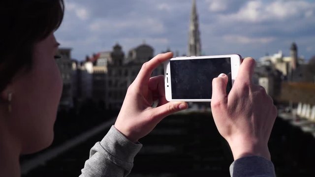Woman tourist takes pictureson on smartphone in Brussels Belgium