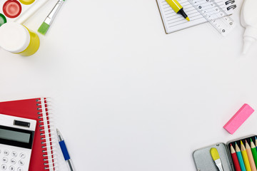 variety of school supplies and tools on white desk background. school stationary flat view