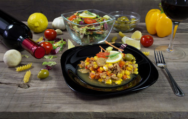 Milanez salat with fresh vegetable, olives, lemon, tomato, papper, garlik, mushrooms and wine in background. Mediterian food