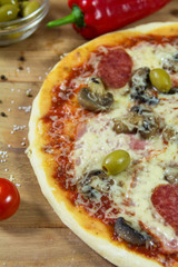 Hot appetite baked pizza with a variety of attachments on the wooden table