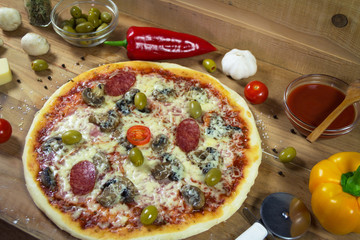 Hot appetite baked pizza with a variety of attachments on the wooden table