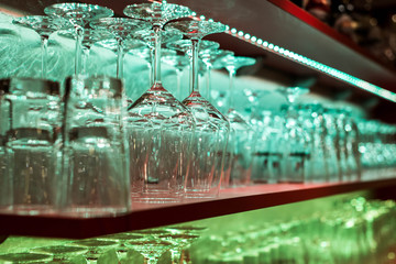 Crystal glass, row and Stack of different glass shelf behind the bar counter, and ready to use