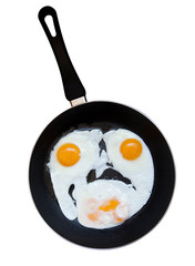 Eggs fried on a pan as a smile. Isolated on a white background with path