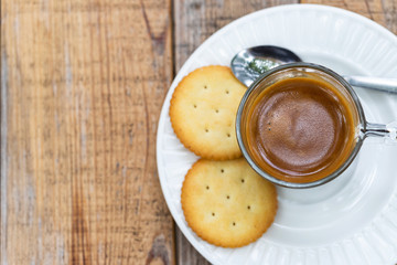 Hot coffee in glass placed on the table with cookies.