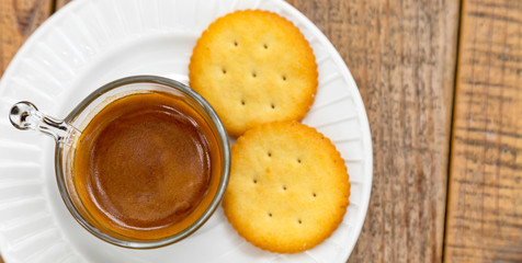 Hot coffee in glass placed on the table with cookies.