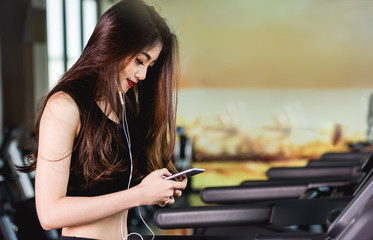 Fototapeta premium Asian woman use smart mobile phone play music exercise