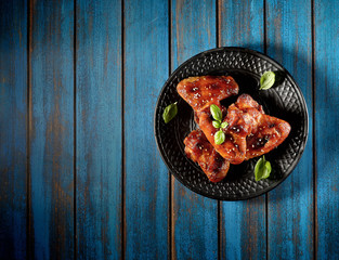 Barbecue on the grill chicken wings on a plate on a wooden background