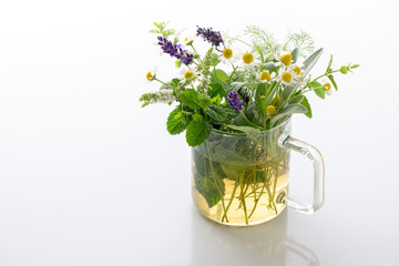 Herbal teal with fresh herbs isolated on white ground,homeopathy